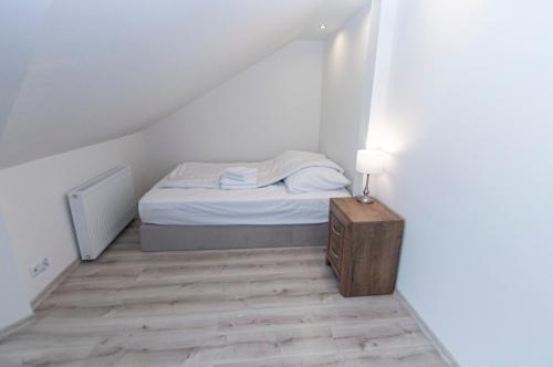 a small bedroom with a bed in a attic at Apartamenty Sowiogórskie in Pieszyce