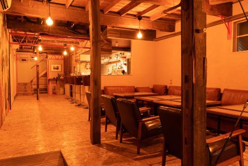 a dining room with wooden tables and chairs at Guesthouse & Kitchen Hace in Iwaki