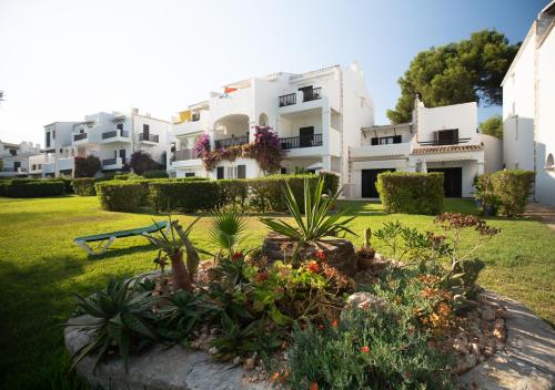 a garden in front of a large white building at Apartamentos Parque Mar in Cala d´Or