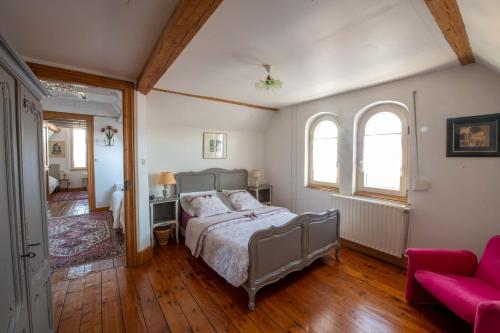 um quarto com uma cama e um sofá vermelho em au-dessus du jardin appartement climatisé em Eckbolsheim