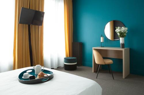 a hotel room with a tray of food on a bed at Hotel Saint Louis in Brest