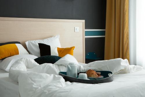 a white bed with a tray of food on it at Hotel Saint Louis in Brest
