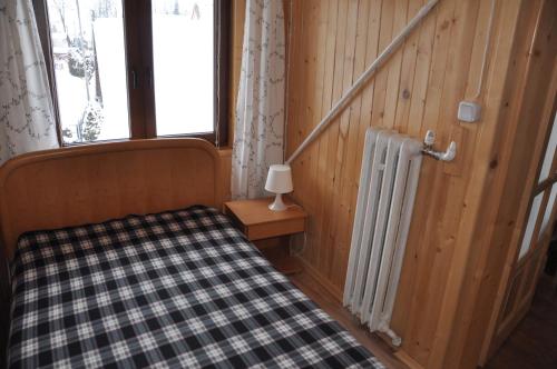 a bedroom with a bed and a window and a radiator at Pod Limbą in Jurgów