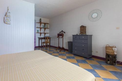 a bedroom with a bed and a dresser in it at Villa élégante à Saint-Paul avec piscine privée ouverte toute l'année in Saint-Paul