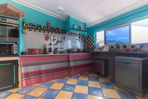 a kitchen with colorful walls and a checkered floor at Villa élégante à Saint-Paul avec piscine privée ouverte toute l'année in Saint-Paul