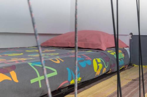 a bed with a colorful comforter and pillows on it at Villa élégante à Saint-Paul avec piscine privée ouverte toute l'année in Saint-Paul