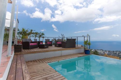 a house with a swimming pool on top of a building at Villa élégante à Saint-Paul avec piscine privée ouverte toute l'année in Saint-Paul
