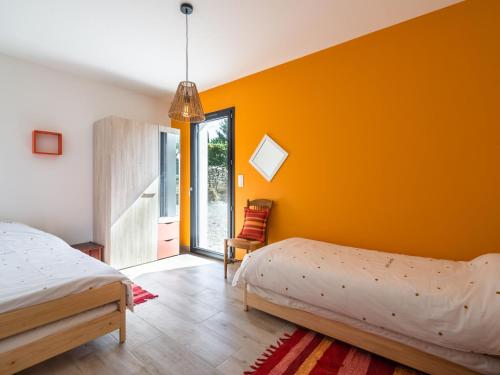 a bedroom with two beds and an orange wall at Holiday Home Beaufort with Private Pool in Beaufort