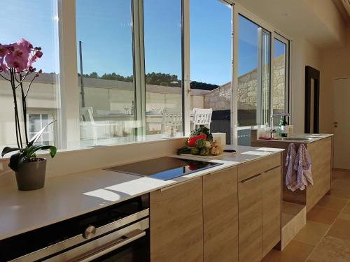 - une cuisine avec de grandes fenêtres et un comptoir avec un évier dans l'établissement Apartment in Villesèque near La Franqui Beach, à Villesèque-des-Corbières