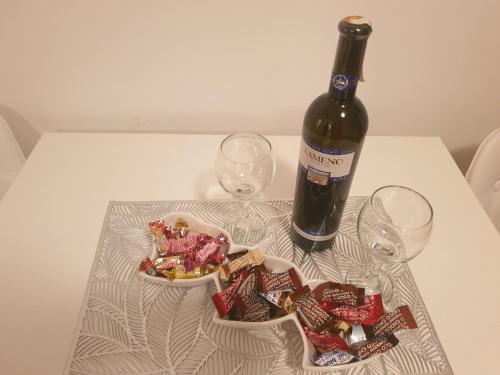 a bottle of wine and two glasses on a table at Apartman Dunjica in Pale