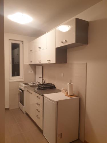 a kitchen with white cabinets and a stove top oven at Apartman Dunjica in Pale