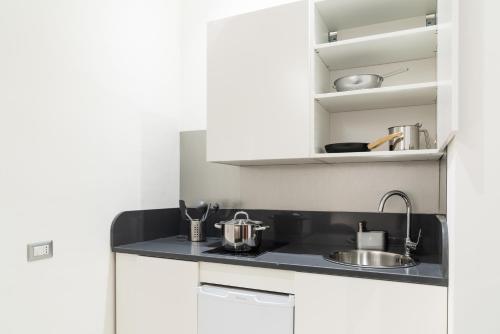 a kitchen with white cabinets and a sink at Residence Sferisterio in Macerata