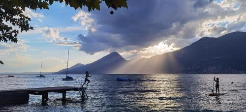 a person on a dock in the water with boats at Hotel S.Maria in Brenzone sul Garda
