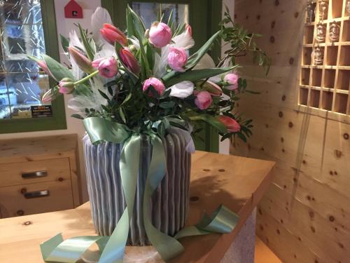 a vase filled with pink flowers on a table at Fedaia Joy B&B in Canazei