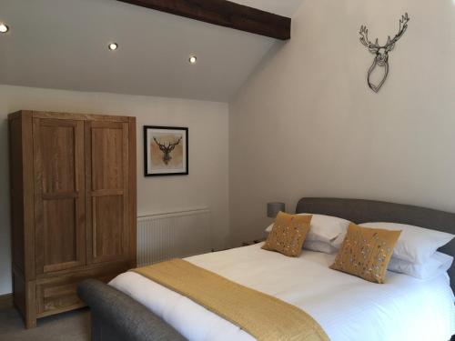 a bedroom with a bed and a wooden cabinet at The Coach House in Southport