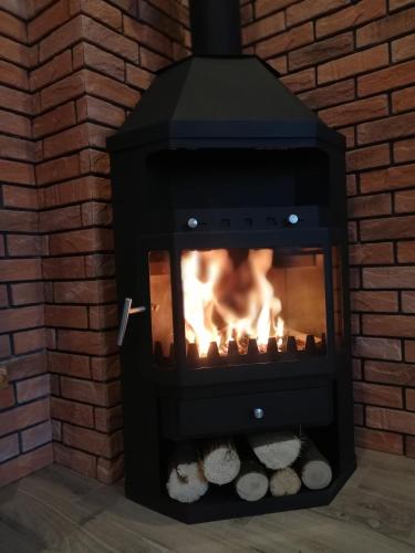a brick fireplace with a fire in it at Słoneczne Chaty Kasina Wielka in Kasina Wielka