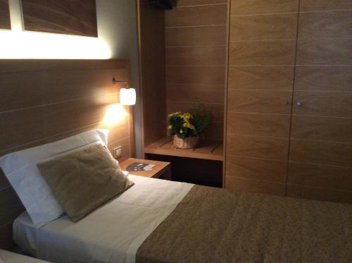 a bedroom with a bed and a night stand with a plant at Meridiana Country Hotel in Calenzano