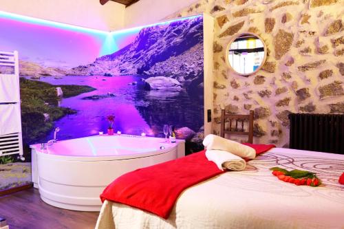 1 dormitorio con bañera y un mural de montaña en Casa Rural El Cuco en Robledillo