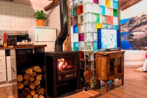 a living room with a fireplace and a television at Casa Rural El Cuco in Robledillo
