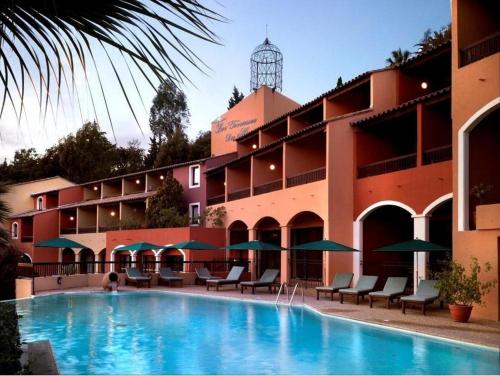 un hôtel avec une piscine devant un immeuble dans l'établissement Résidence Les Terrasses du Mirage - Duplex vue mer, à Bormes-les-Mimosas