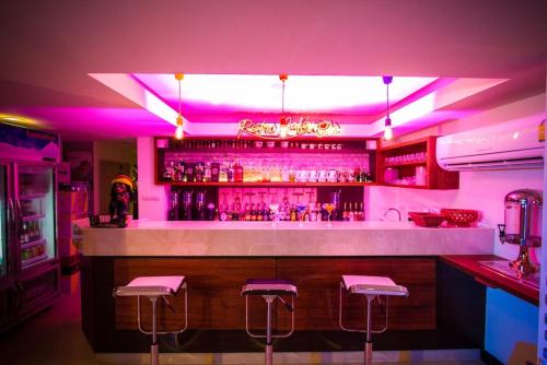 a bar with pink lighting and bar stools at Retro39 in Bangkok