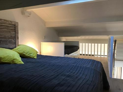 - une chambre avec un lit doté de draps bleus et d'oreillers verts dans l'établissement Résidence Les Terrasses du Mirage - Duplex vue mer, à Bormes-les-Mimosas