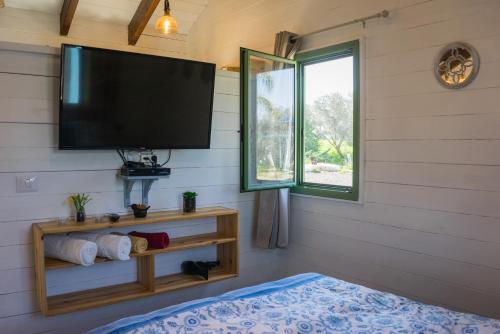 a room with a flat screen tv and a window at Provence in the Valley in Kefar Barukh