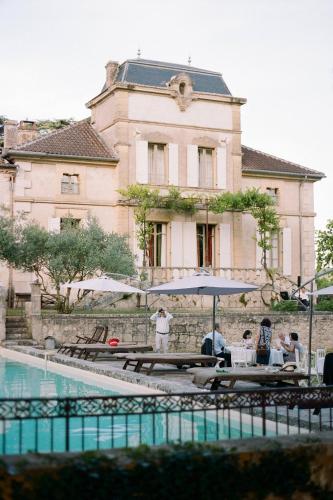 un groupe de personnes assises à des tables devant un bâtiment dans l'établissement Stunning Castle South FranceP, à Monjoi