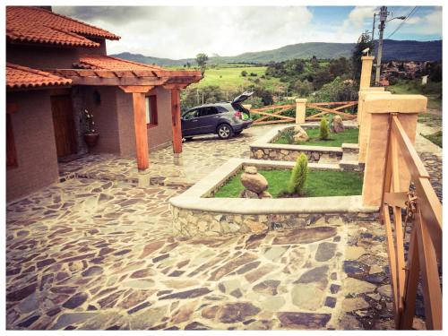 a house with a car parked in a driveway at Beautiful Cabin Downtown Tapalpa Oven Mud Barbecue Grill 4 Room 12 ppl TV Wifi in Tapalpa