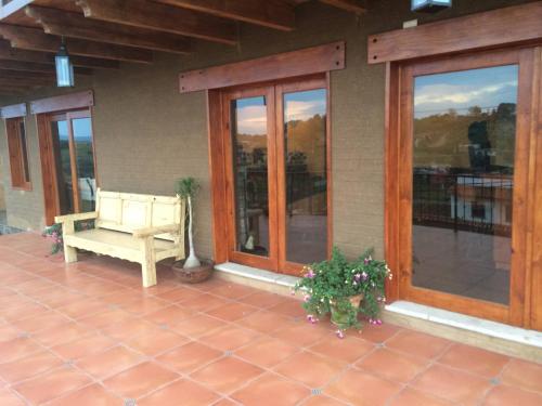 a porch of a house with a bench and windows at Beautiful Cabin Downtown Tapalpa Oven Mud Barbecue Grill 4 Room 12 ppl TV Wifi in Tapalpa