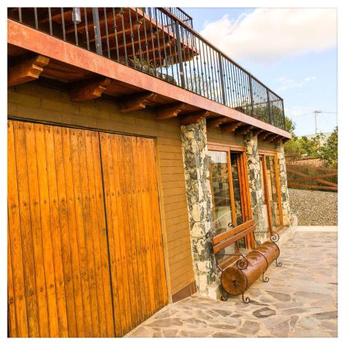 a house with a wooden gate and a balcony at Beautiful Cabin Downtown Tapalpa Oven Mud Barbecue Grill 4 Room 12 ppl TV Wifi in Tapalpa