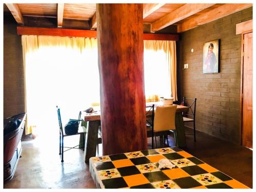 a room with a checkered bed and a table at Beautiful Cabin Downtown Tapalpa Oven Mud Barbecue Grill 4 Room 12 ppl TV Wifi in Tapalpa