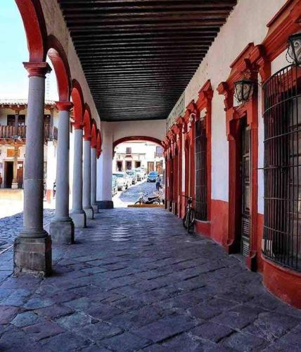 an empty hallway of a building with columns and an arcade at Beautiful Cabin Downtown Tapalpa Oven Mud Barbecue Grill 4 Room 12 ppl TV Wifi in Tapalpa