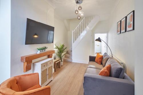 a living room with a couch and a tv at Host & Stay - Fountains Cottage in Guisborough