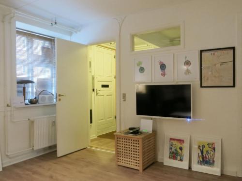 sala de estar con TV de pantalla plana en la pared en ApartmentInCopenhagen Apartment 1316 en Copenhague