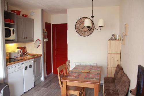 uma cozinha com uma mesa e uma pequena cozinha com uma mesa e uma mesa; em Beau deux pièces Isola 2000 em Isola 2000