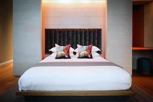 a bedroom with a white bed with two pillows at Malmaison Cheltenham in Cheltenham