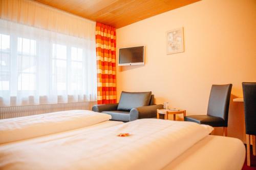 um quarto de hotel com duas camas e duas cadeiras em Herrenschenke-Café Eiring em Königsberg in Bayern