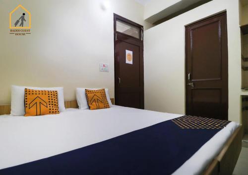 um quarto com uma cama com almofadas laranja e azul em Baddi Guest House em Baddi