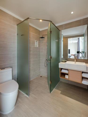 a bathroom with a shower and a toilet and a sink at The Empire Hotel in Phu Quoc