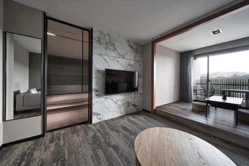 a hotel room with a large glass door with a television at Yen Hotspring in Ruisui