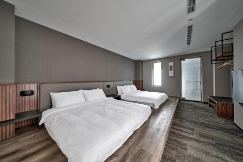a bedroom with two beds and a tv at Yen Hotspring in Ruisui