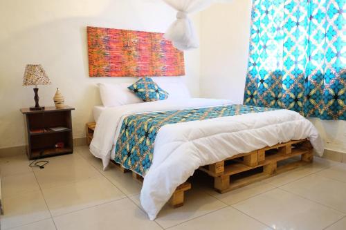 a bedroom with a bed and a window at INZOZI AFRICA HOUSE B&B- Kacyiru in Kigali