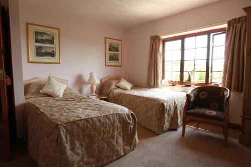 una camera d'albergo con due letti e una finestra di Pointers Guest House a Wistow