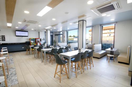a restaurant with tables and chairs and windows at Hotel Leo in Monesterio