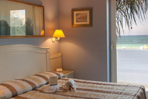 a bedroom with a bed with a view of the ocean at Conchiglia Azzurra Resort & Beach in Porto Cesareo