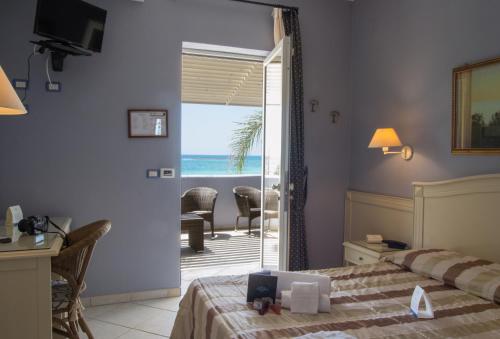 a bedroom with a bed and a view of the ocean at Conchiglia Azzurra Resort & Beach in Porto Cesareo