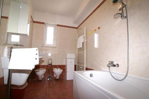 a bathroom with two toilets and a bath tub at Apartment Andrina in Vantačići