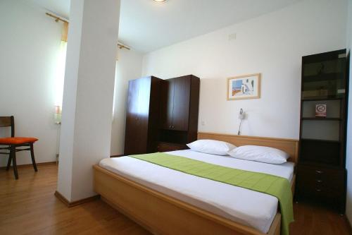 a bedroom with a bed with a green and white blanket at Apartment Andrina in Vantačići