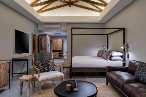 a living room with a bed and a couch at Kruger Gate Hotel in Skukuza